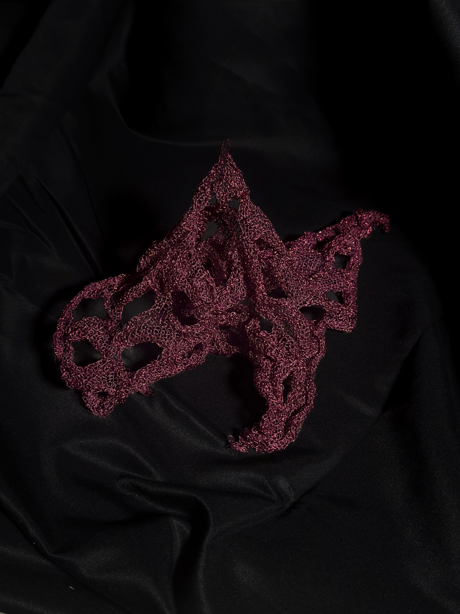 Final photograph of the knitted sample against folded black cloth
